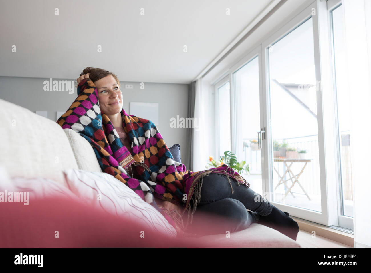 Smiling woman relaxing on the couch Stock Photo - Alamy