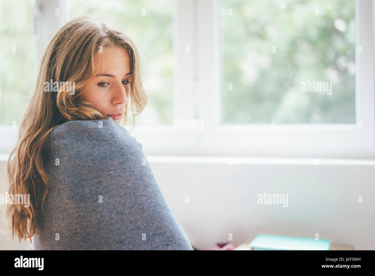 Portrait of young woman wrapped in a blanket Stock Photo - Alamy