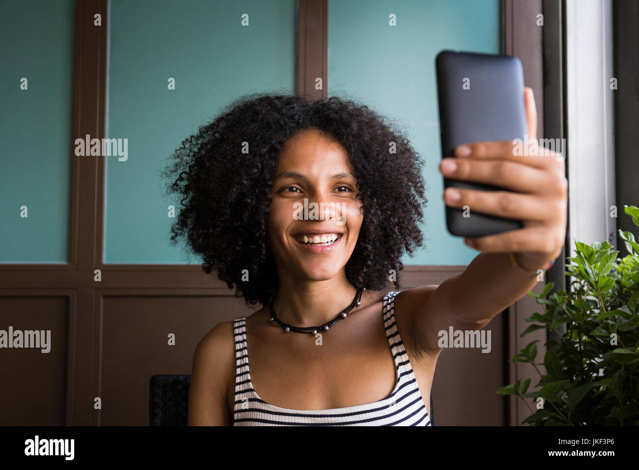 Happy young woman taking selfie in a coffee shop Stock Photo - Alamy