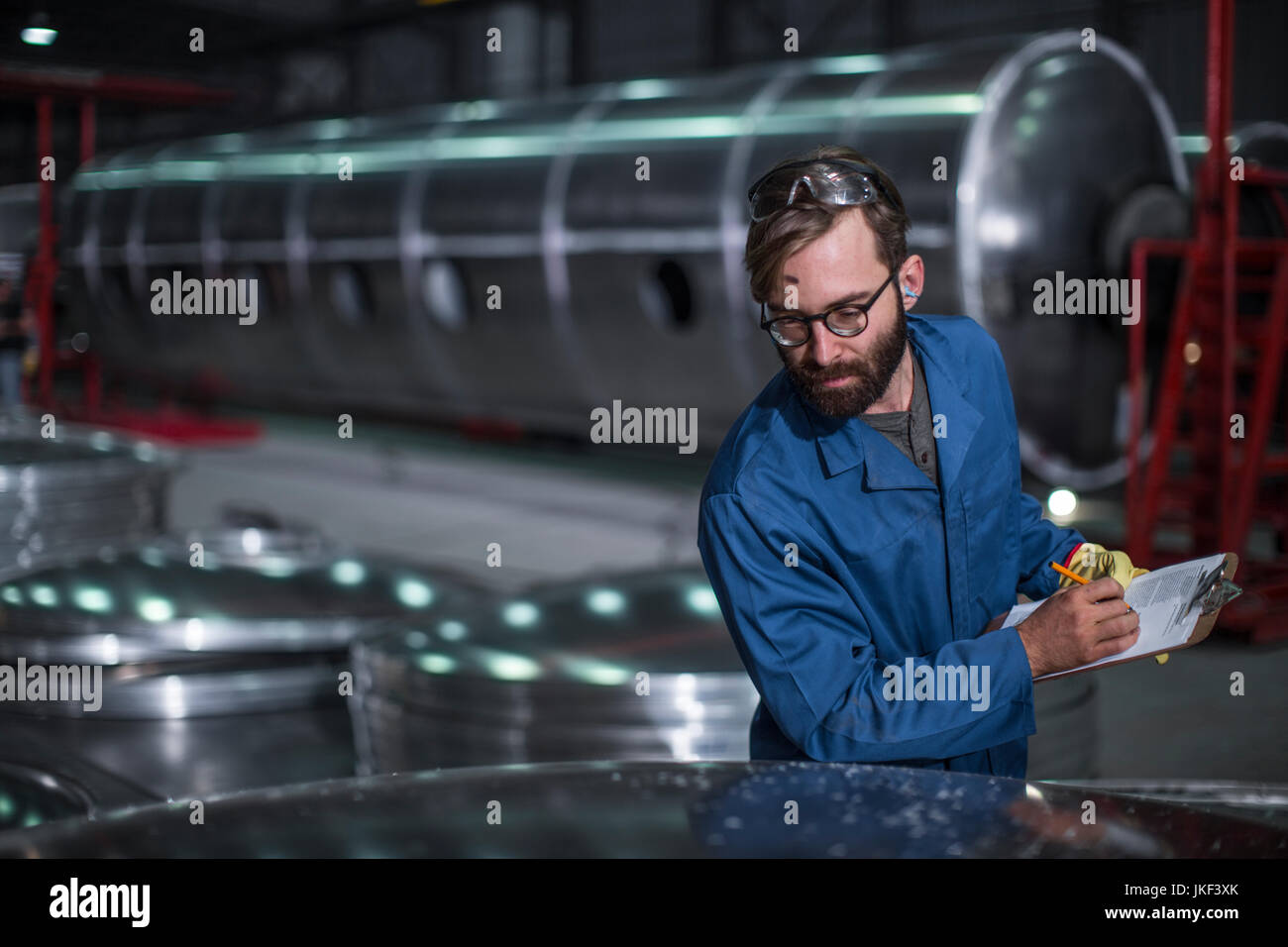 Worker with clipboard in factory Stock Photo - Alamy