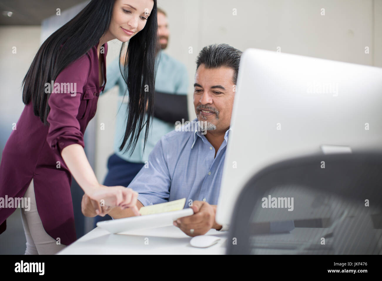 Office Employee Assisting Her Colleague With Paperwork Stock Photo