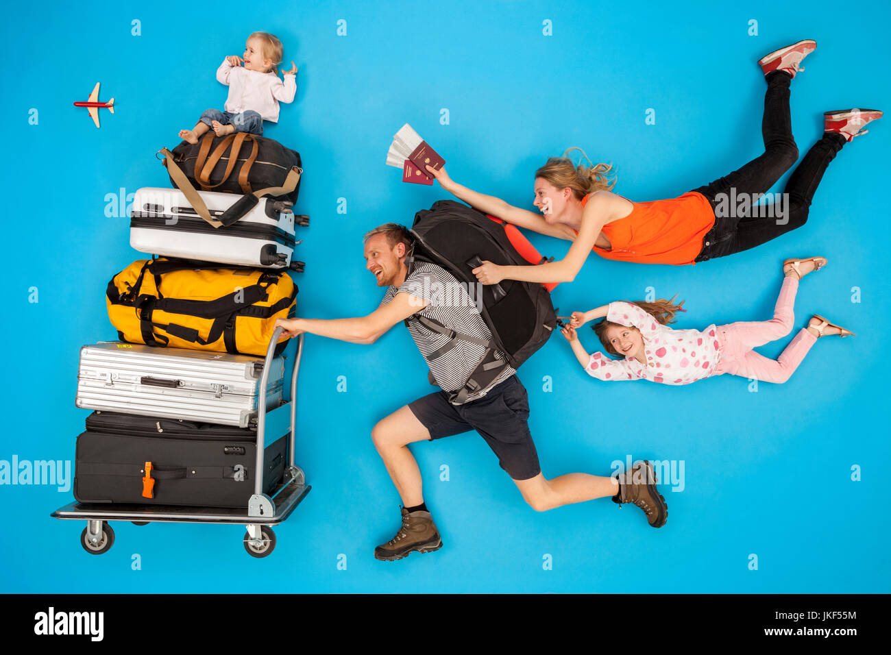 Family with luggage trolley hurrying for departure Stock Photo