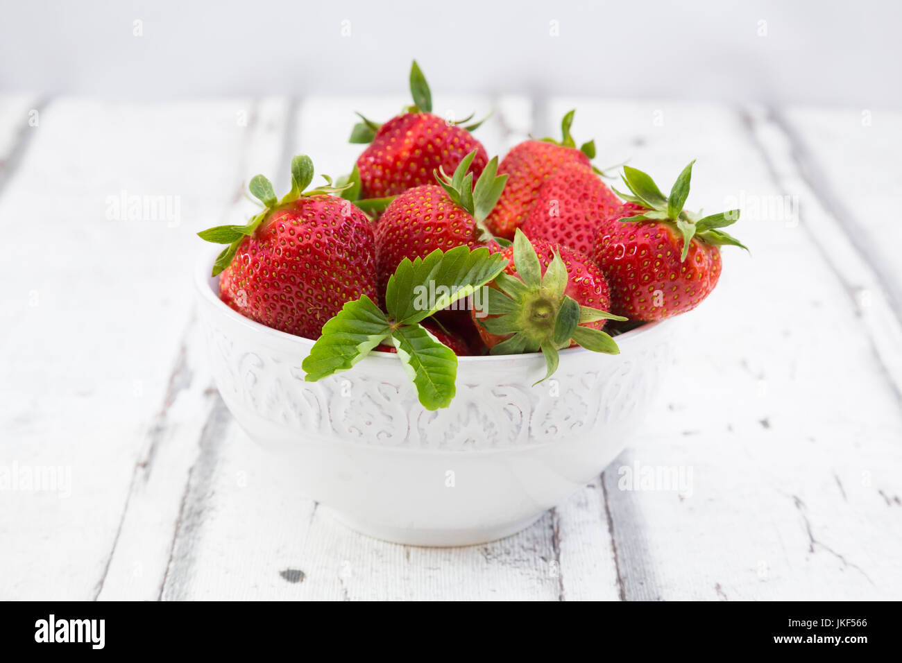 Bowl of strawberries on white wood Stock Photo - Alamy