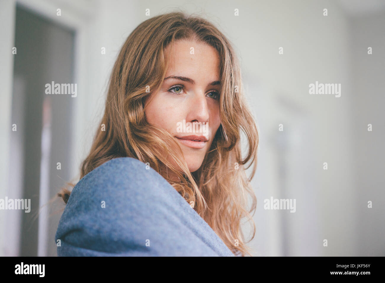 Portrait of young woman wrapped in a blanket Stock Photo - Alamy