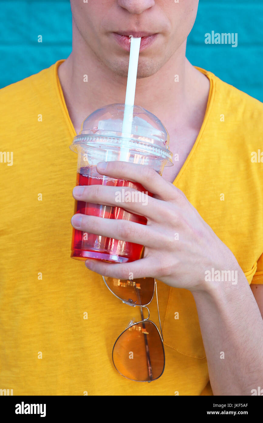 Young man drinking soft drink, partial view Stock Photo