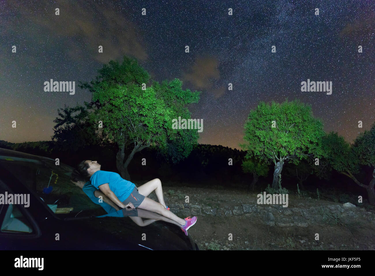 Woman lying on top of a night car in the starlight. Shot taken in the  Sierra del Segura, province of Albacete in Spain Stock Photo - Alamy