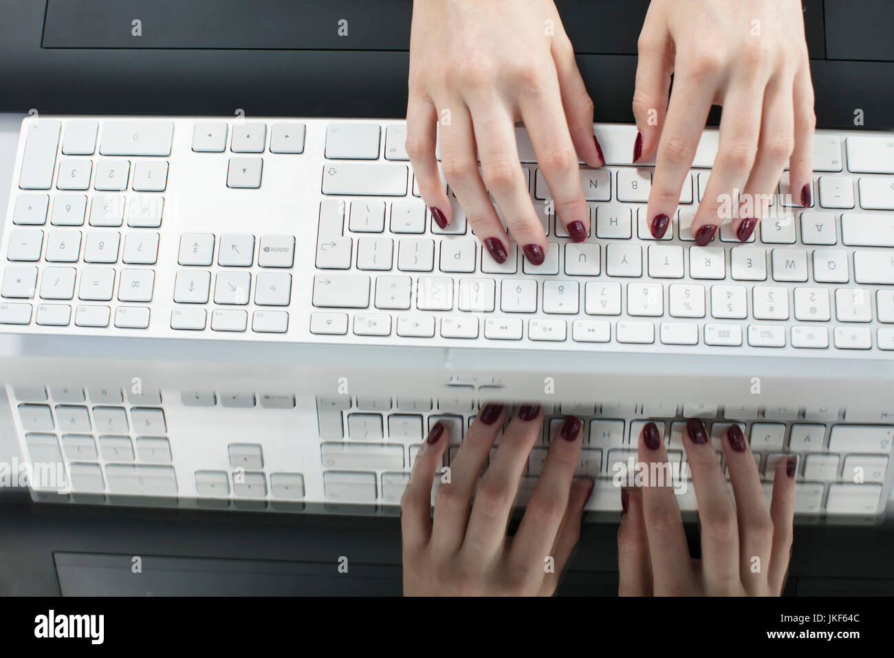 Female hands typing on a keyboard Stock Photo