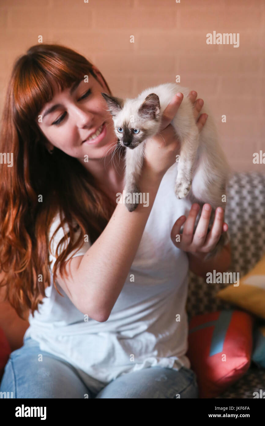 Young woman with kitten at home Stock Photo