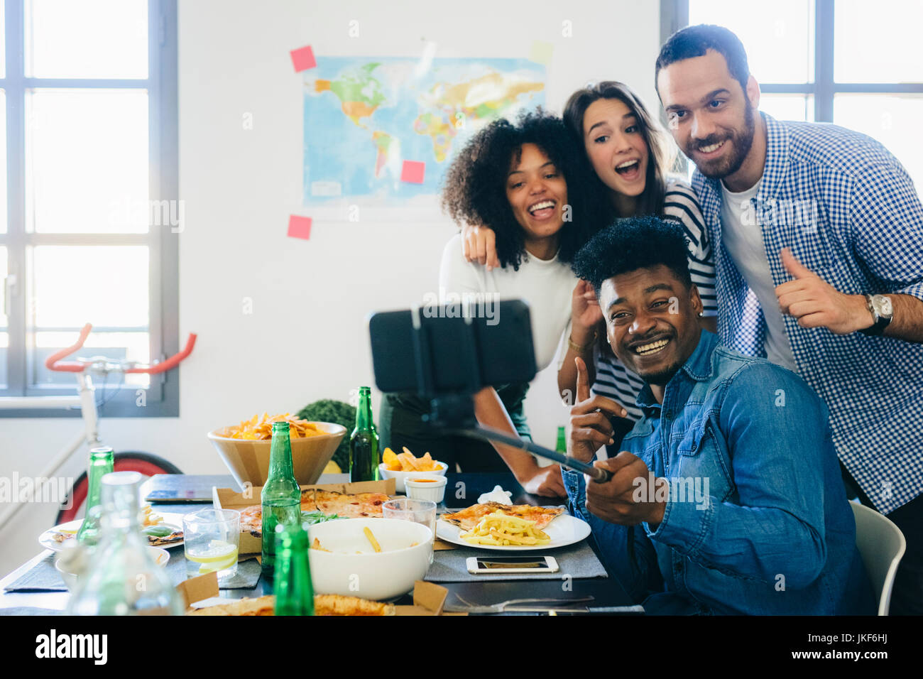 Group of friends posing for a selfie at dining table at home Stock ...
