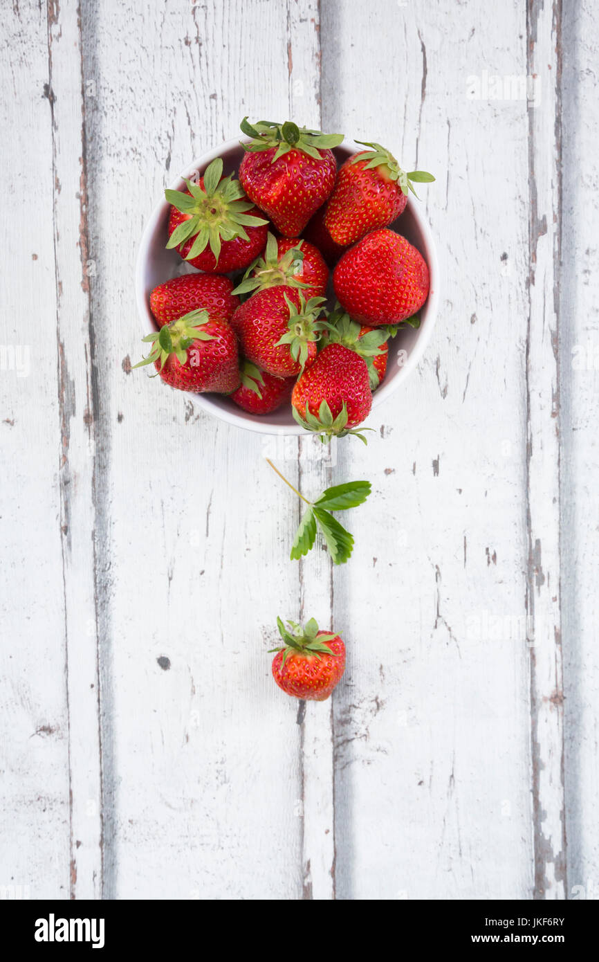 Bowl of strawberries on white wood Stock Photo - Alamy