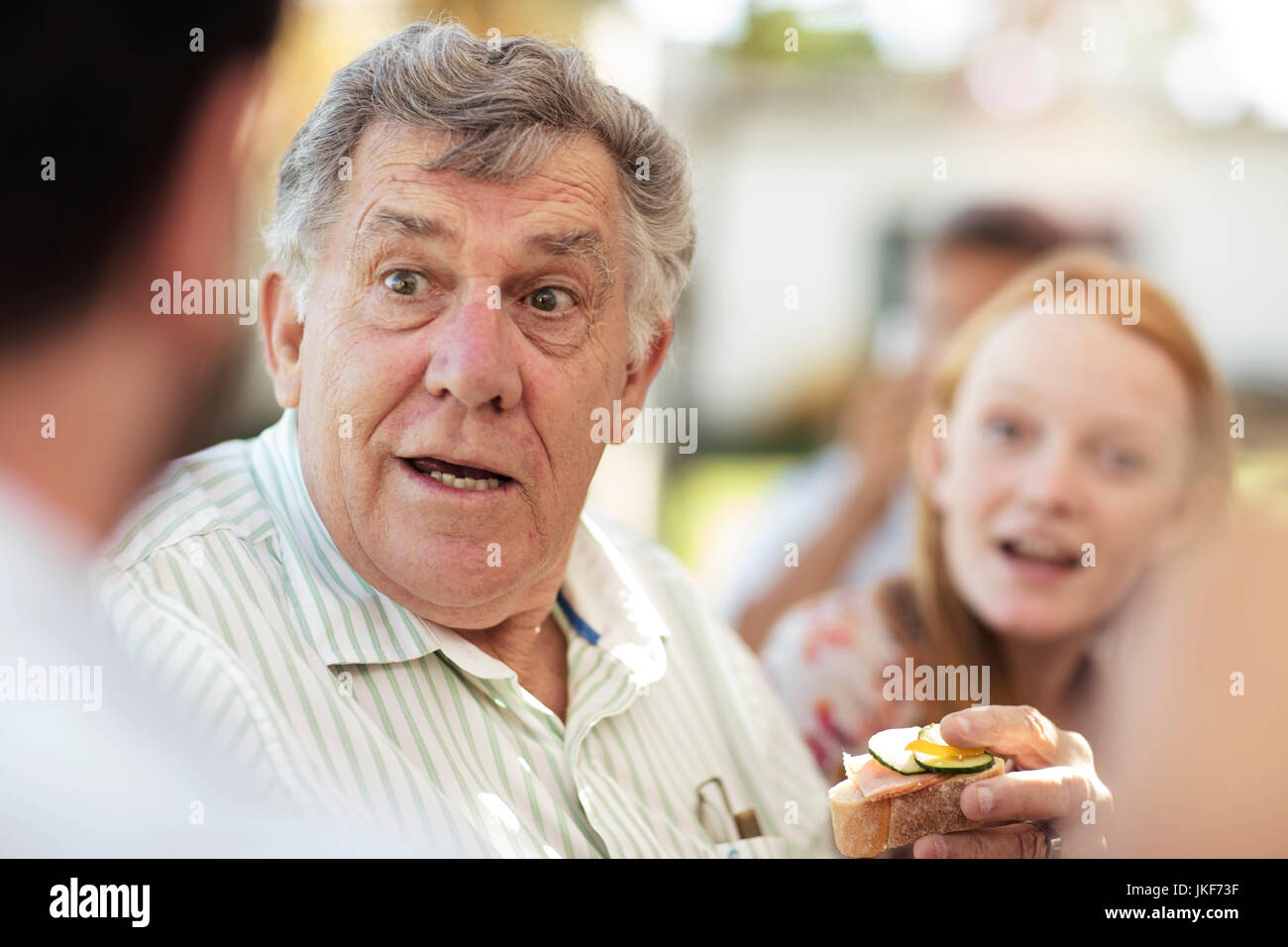 Senior man socializing on a garden party Stock Photo