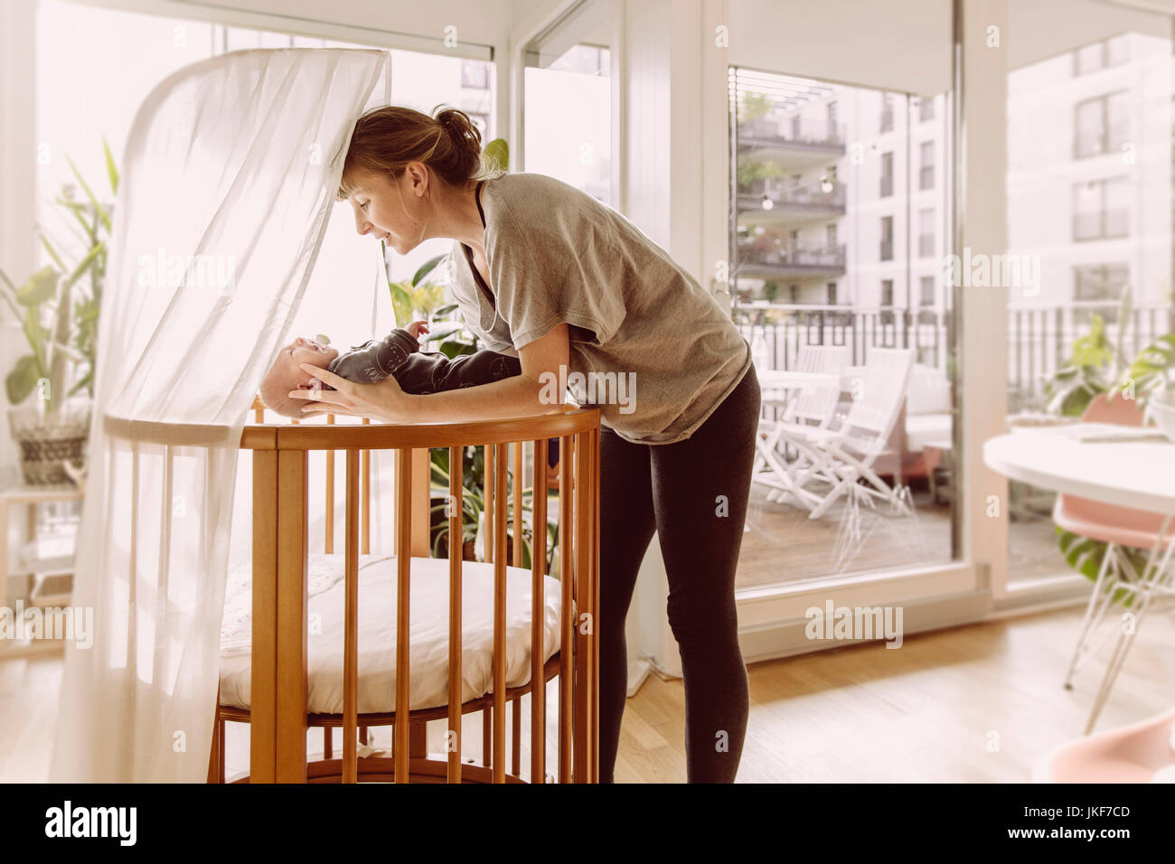 Mother laying her newborn baby boy into crib Stock Photo Alamy