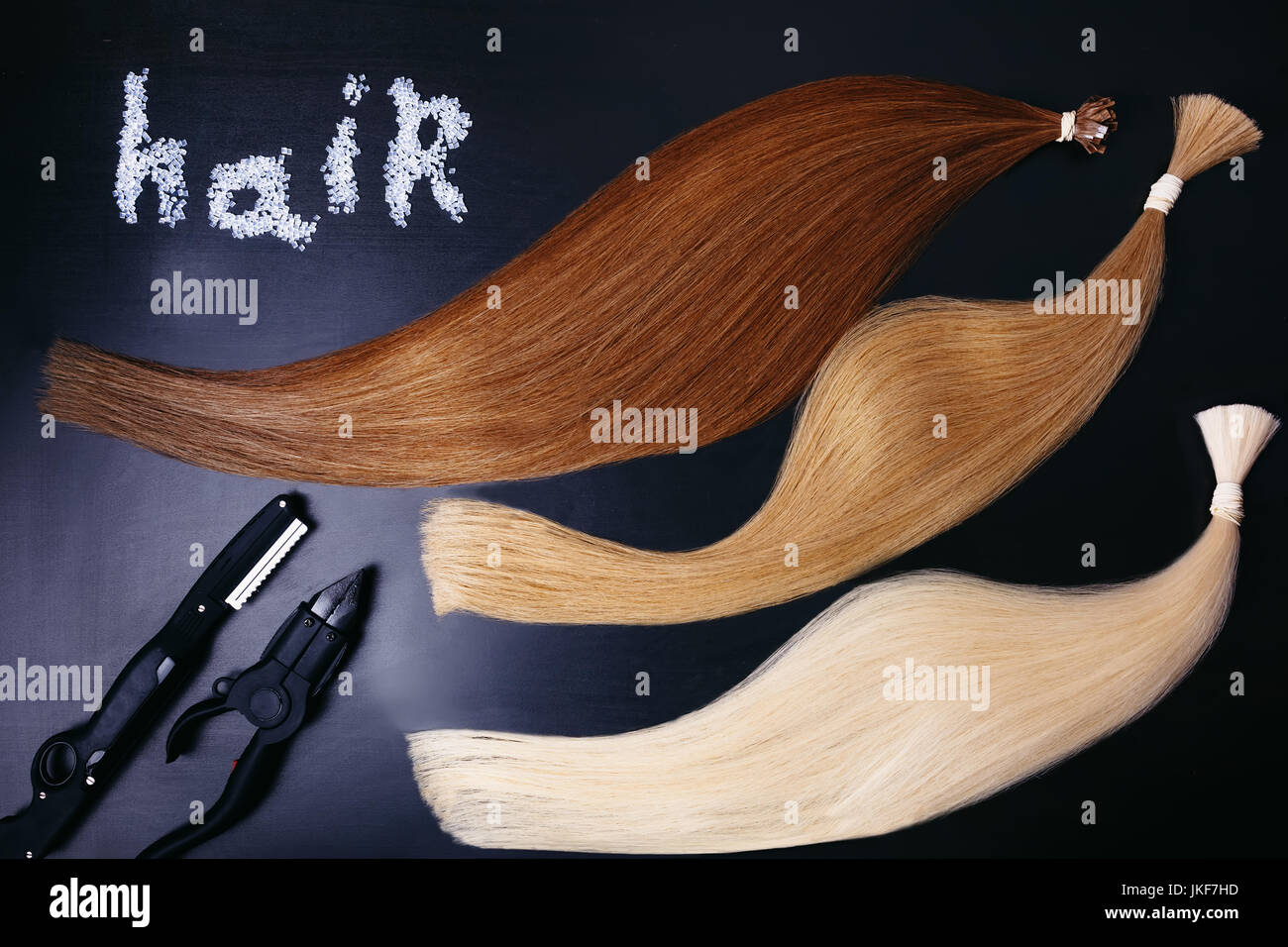 Set of of three colors hair extension tools on a dark background. copyspace. top view. Stock Photo