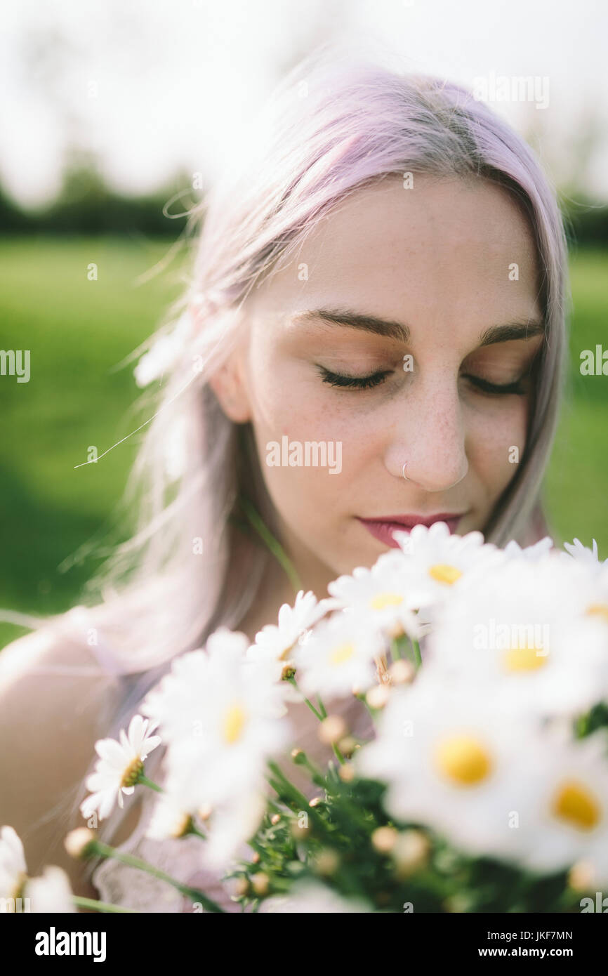 Woman with eyes closed holding bunch of daisies Stock Photo - Alamy