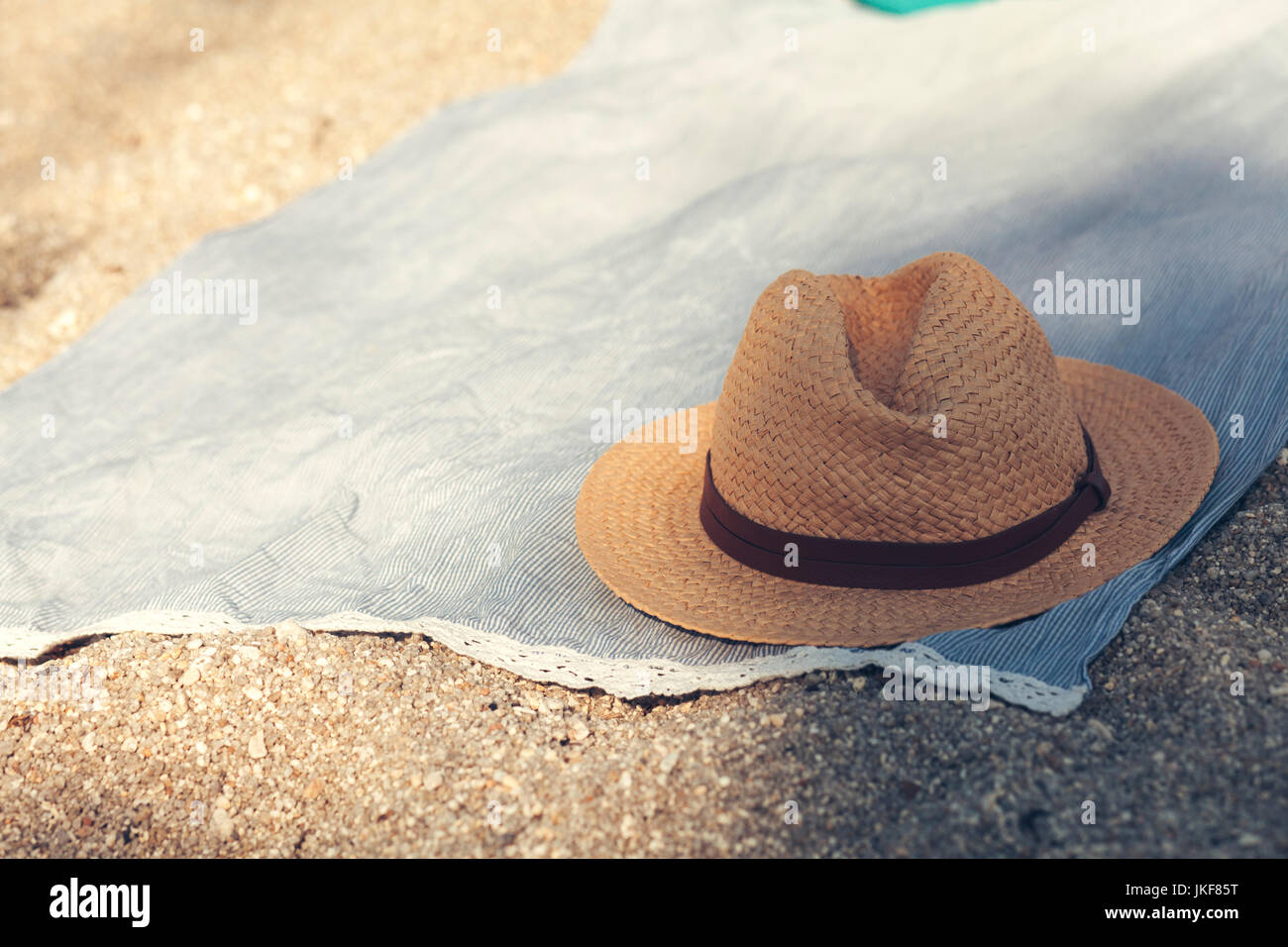 Straw hat on cloth on sandy beach Stock Photo - Alamy