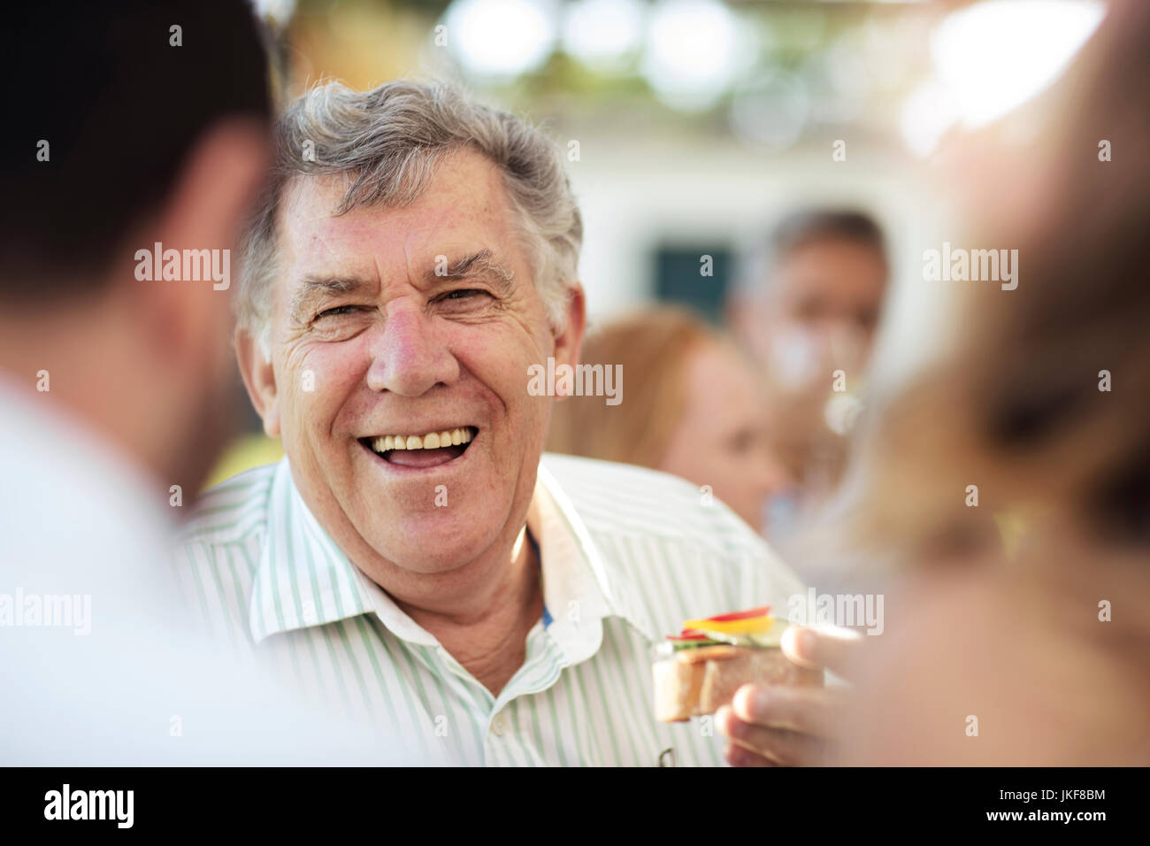 Happy senior man socializing on a garden party Stock Photo