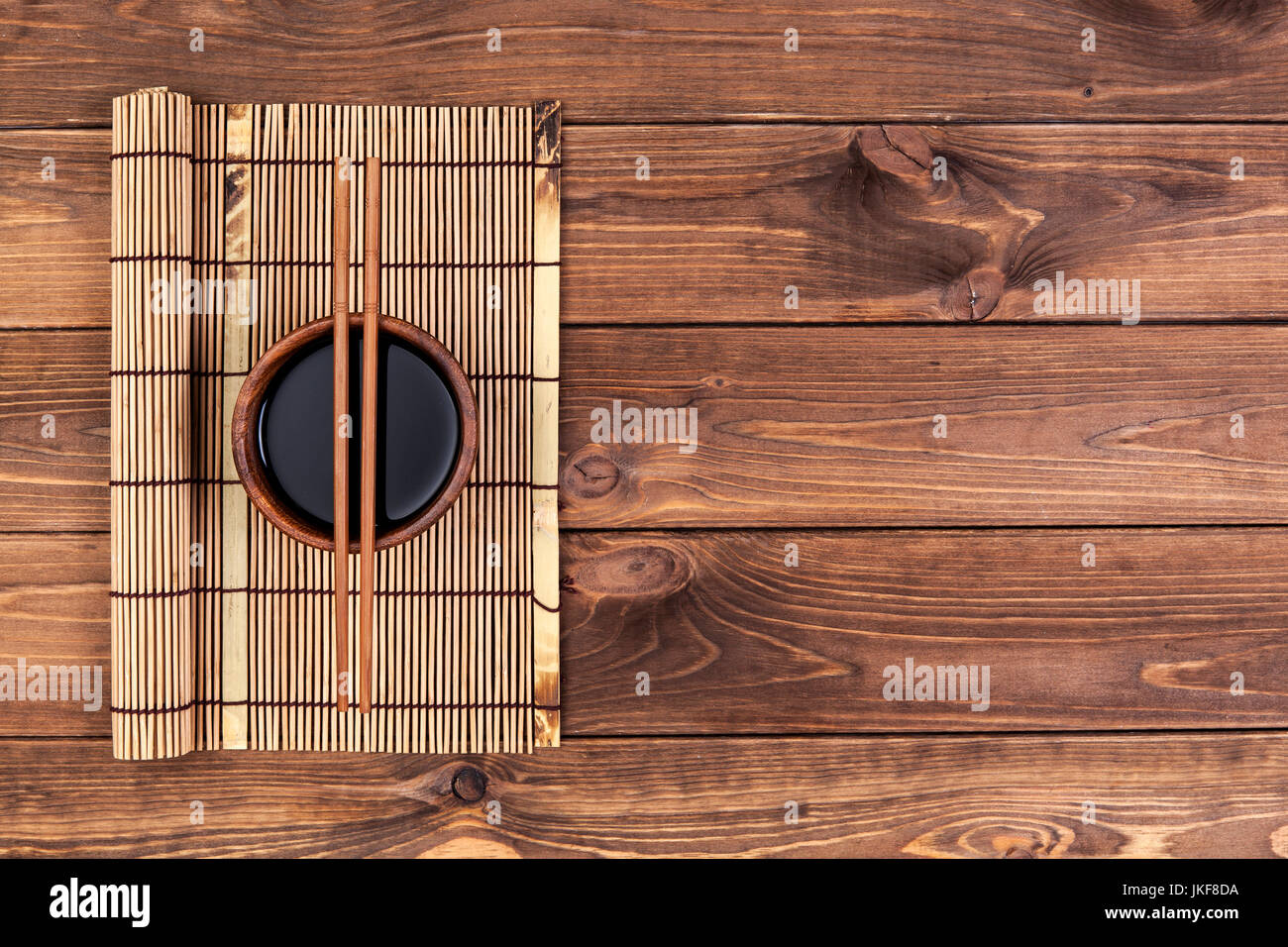 Mat for sushi and chopsticks on wooden background. Stock Photo