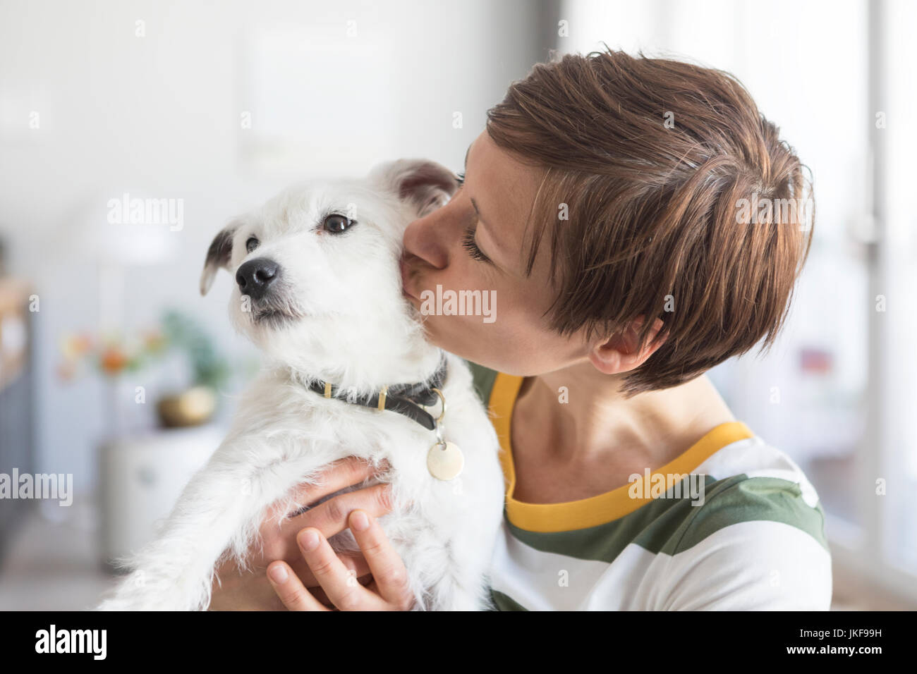 Woman kissing her dog Stock Photo