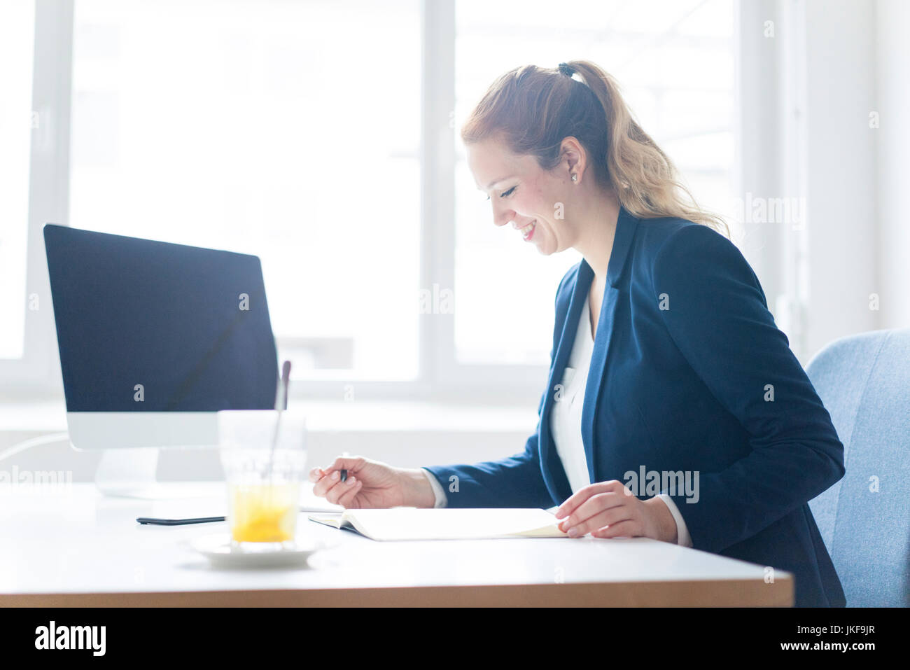 Businesswoman working at desk in her office Stock Photo - Alamy