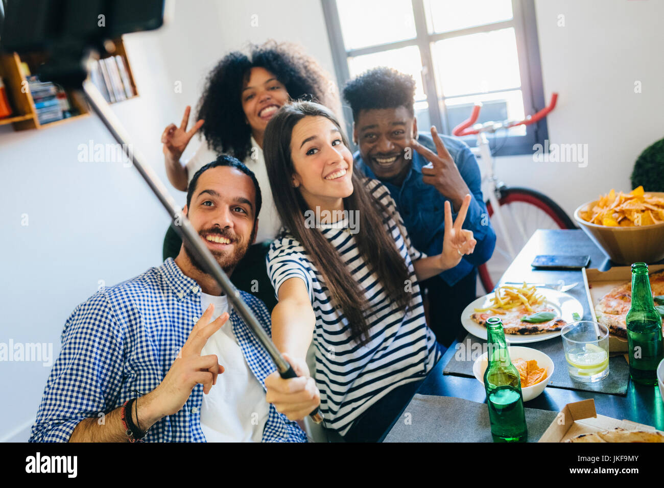 Group of friends posing for a selfie at dining table at home Stock ...