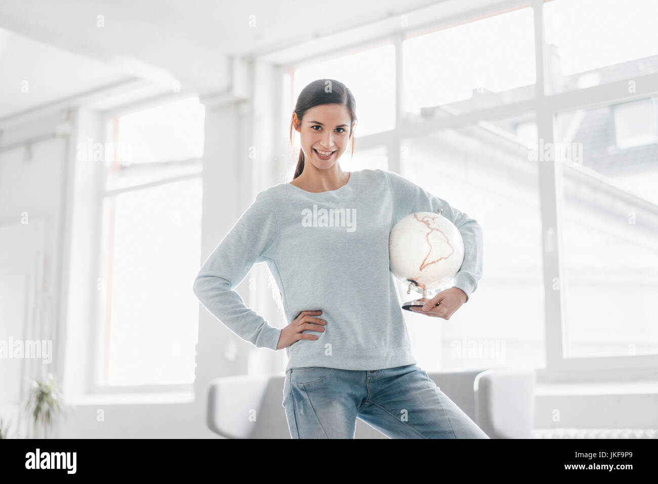 Young woman holding globe, planning world trip Stock Photo