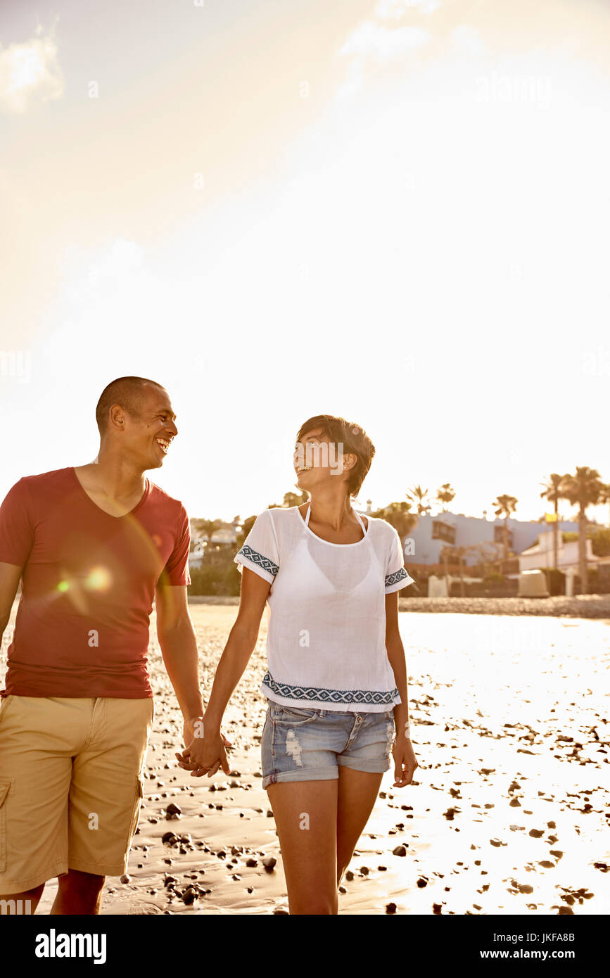 Couple in love walking hand in hand on the beach Stock Photo - Alamy
