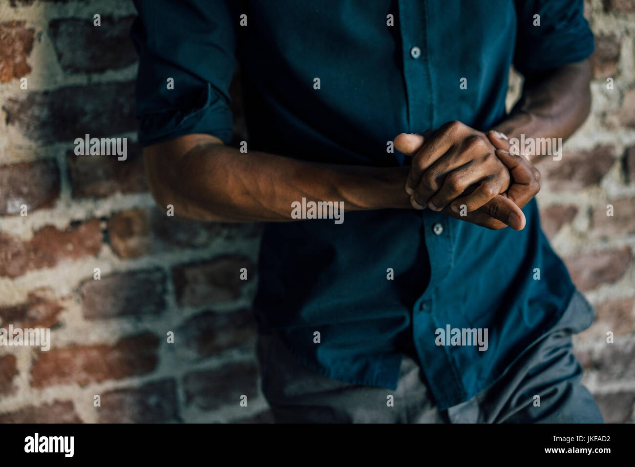 Hands of man leaning against brick wall Stock Photo - Alamy
