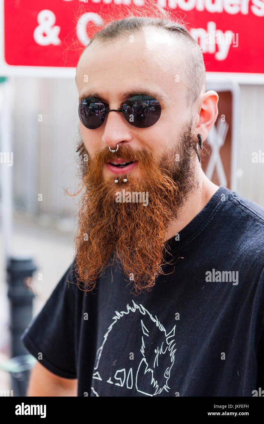 Portrait, face, Caucasian man, 20s, long brown beard, short hair, black  round sunglasses. Metal stud piercings chin and nose. Eye-contact Stock  Photo - Alamy