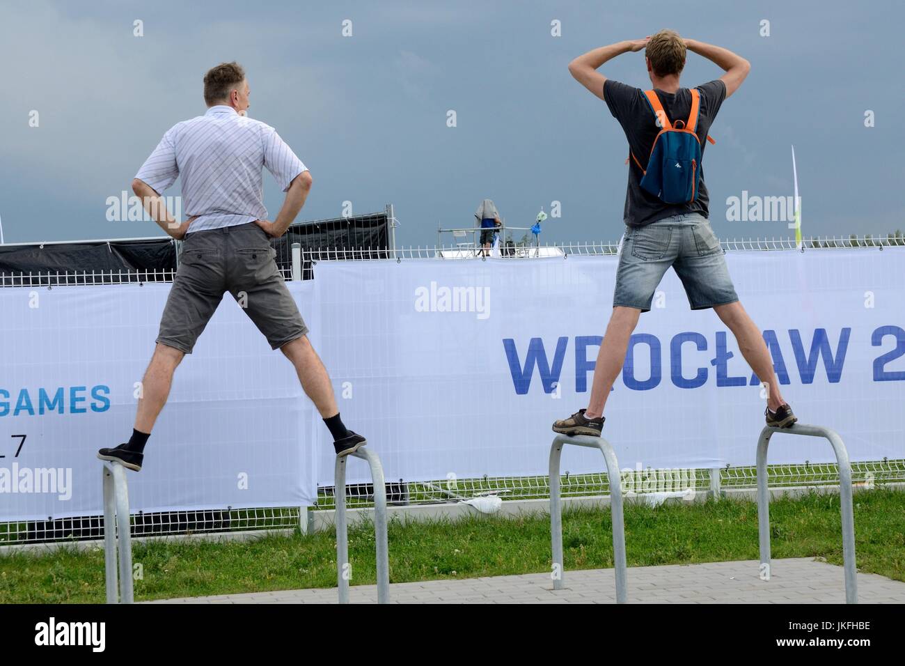 The World Games, an international multi-sport event is hold on July 20 in Wroclaw, Poland. Skating park in Milenium Park. Woman's Speed skating competition, Women's Elimination Race 15000m Final.    In the picture: two men watching competition outside of tribune, no more tickets available. Stock Photo