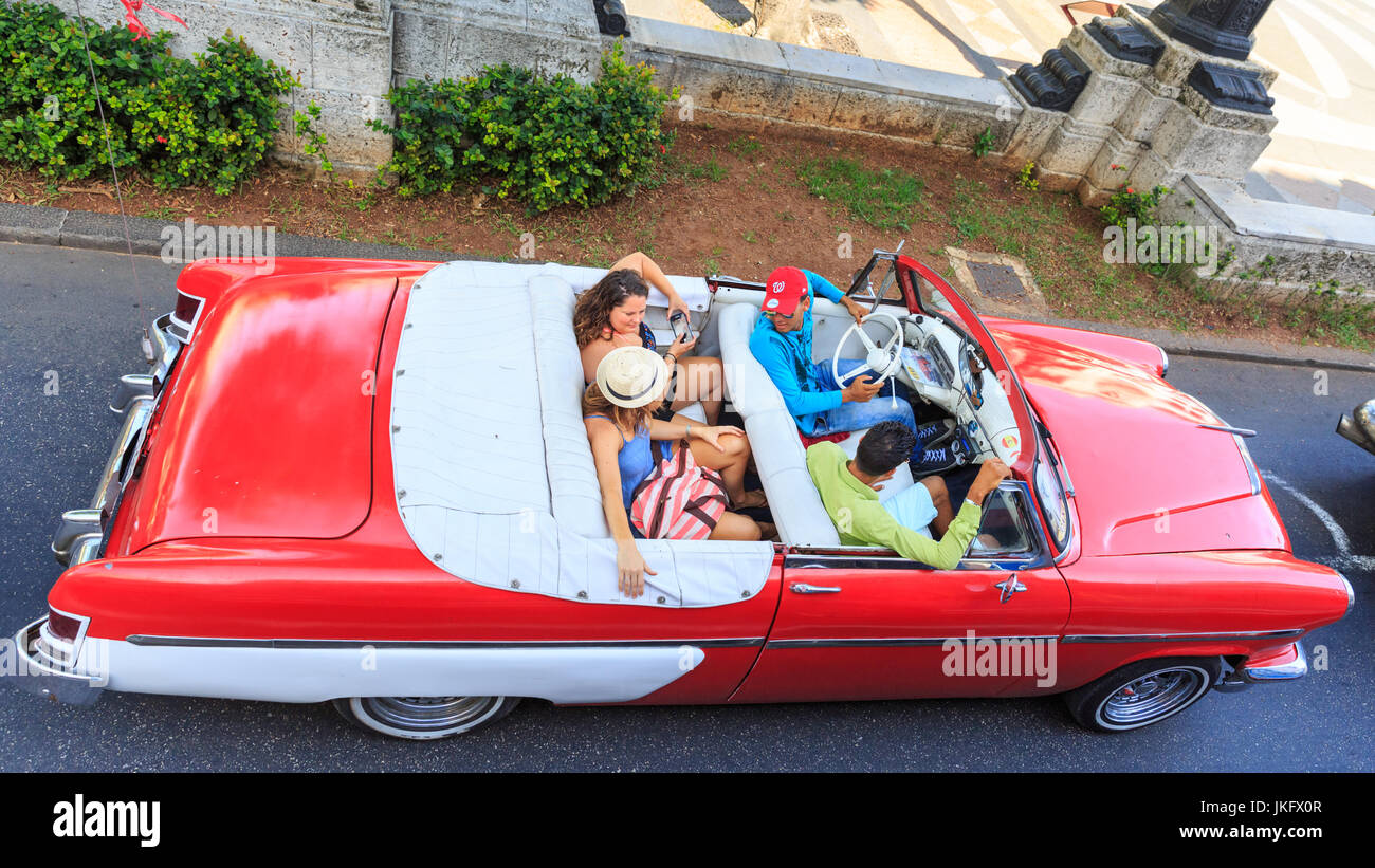Tourists and driver in a red convertible American classic car, high angle pov, Havana, Cuba Stock Photo
