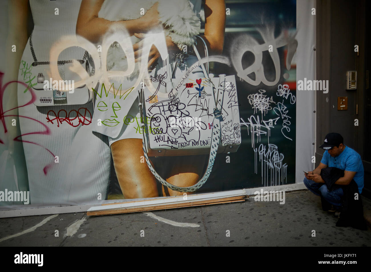 New York City, Manhattan, Graffiti tags vandalise on a street advertisement on Broadway in Canal street area Stock Photo