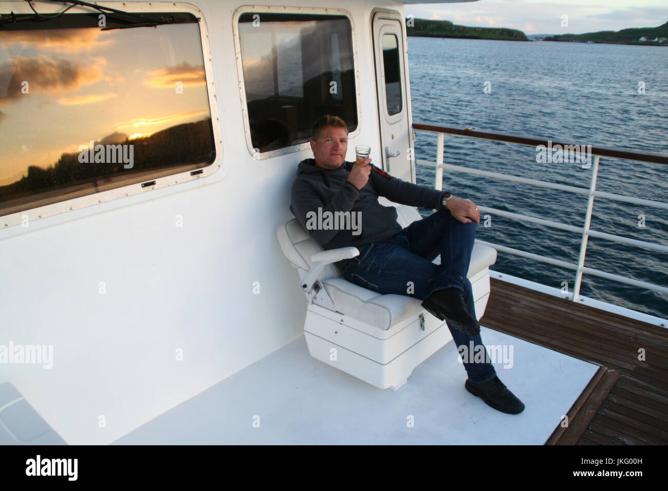 Tourist Relaxing on the Proud Seahorse, Cruising the Scottish Hebridean Islands Stock Photo
