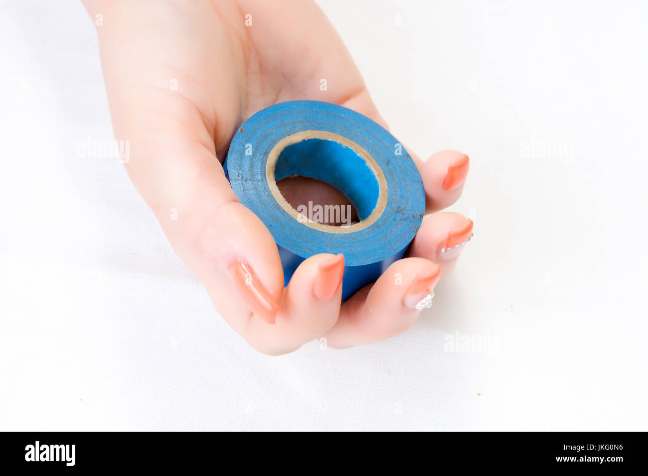 woman holding blue electrical isolation tape in hand with nail art isolated on white background Stock Photo
