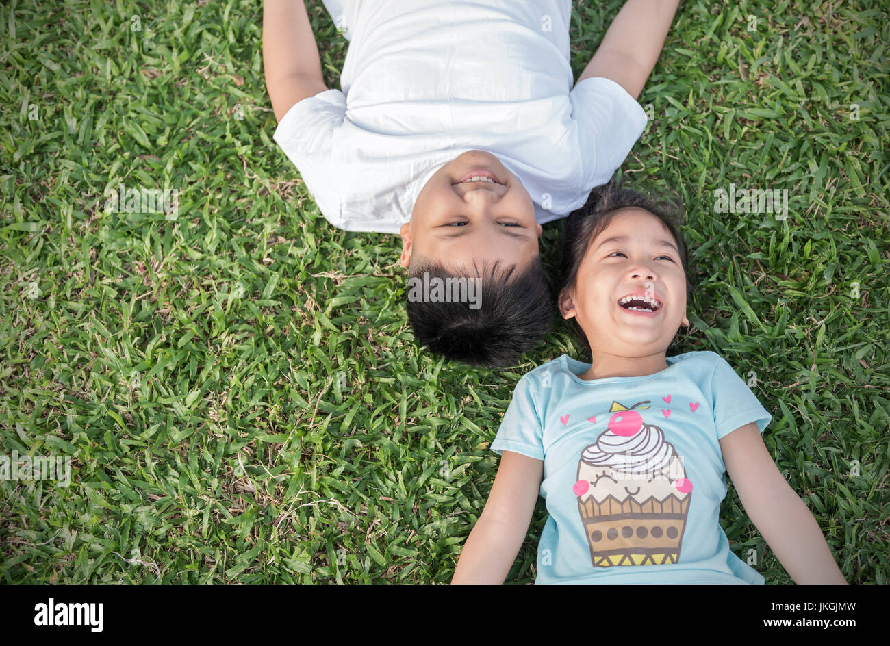 Smile children lie down on grass, concept recreation and liesure Stock Photo