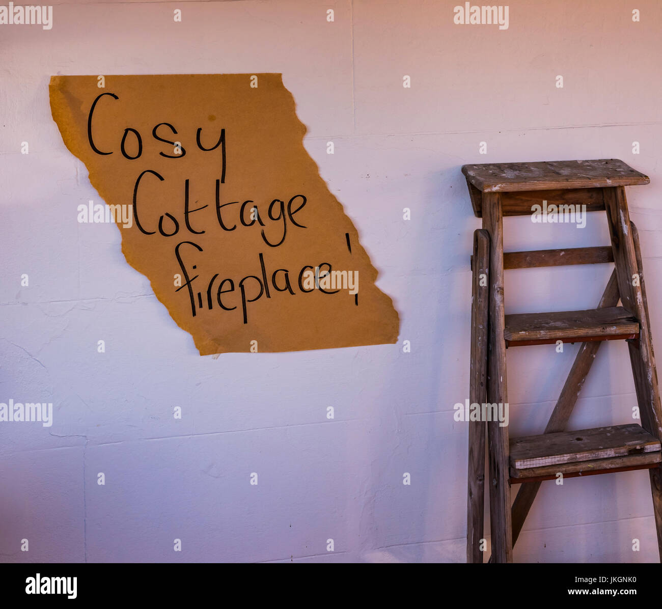 Painters ladder standing against a white wall outside a cafe 'Cosy Cottage Fireplace' in Hahndorf, South Australia Stock Photo