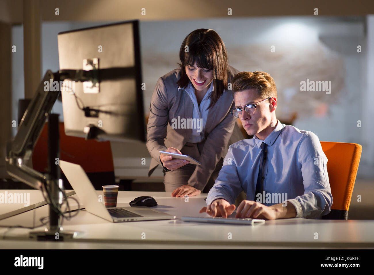 Two young designers are working on a new project in the night office ...