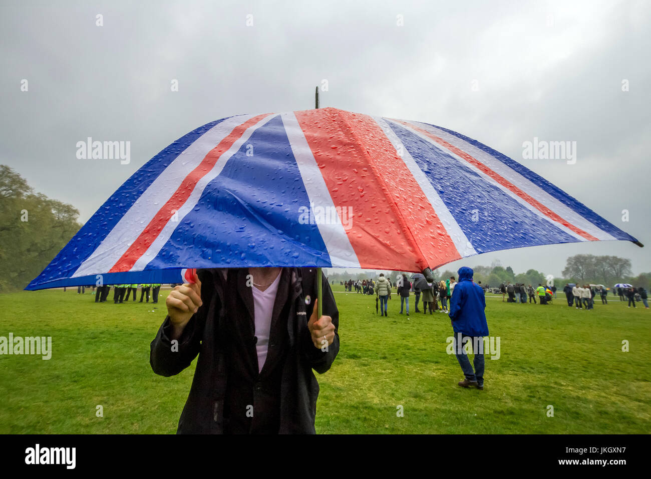 British union flag umbrella during rain and wet weather in London's Hyde Park. Stock Photo