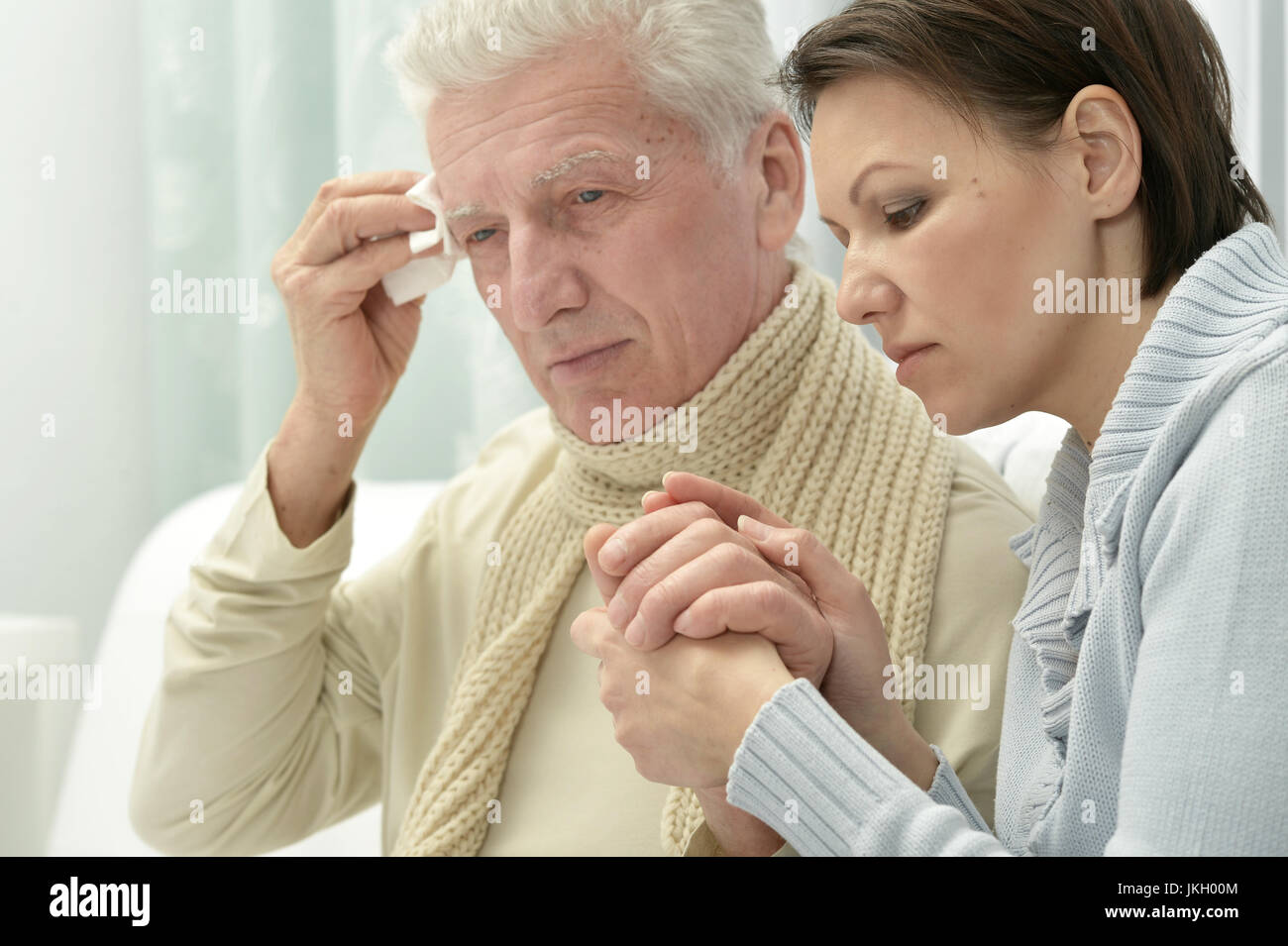 Young woman taking care of ill senior man Stock Photo