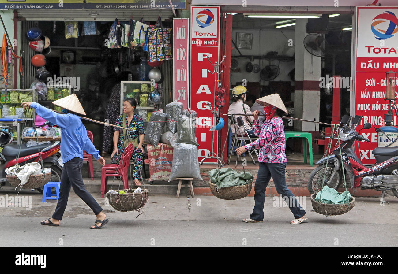 Street scene people carrying goods Hanoi Vietnam. Stock Photo