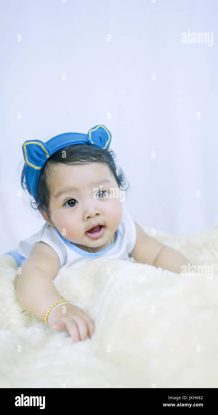 Asian Smiling baby girl crawling in bedroom Stock Photo