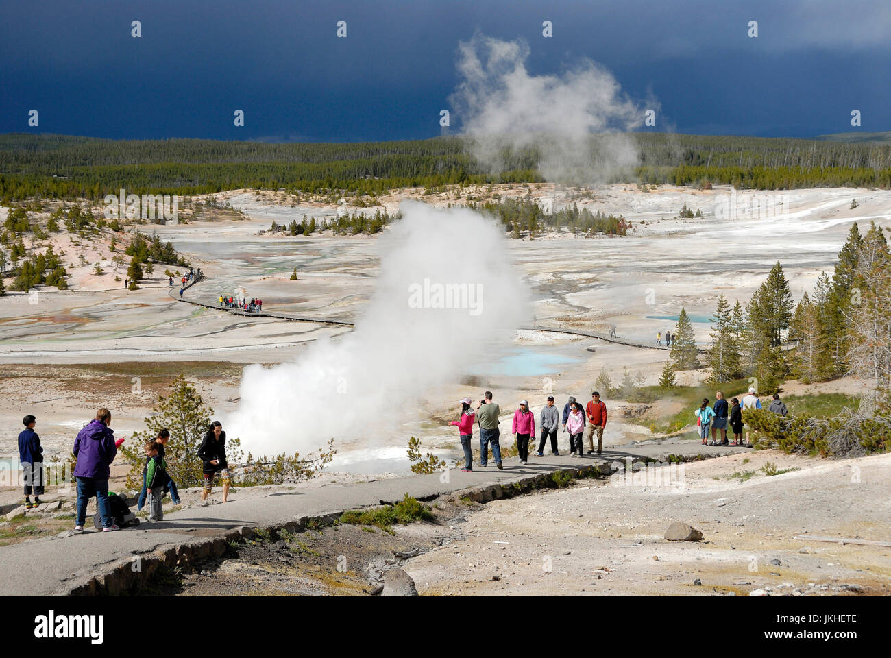 Visitors at Norris Geyser Basin with storm clouds moving in,Yellowstone Nation Park, Wyoming, USA Stock Photo