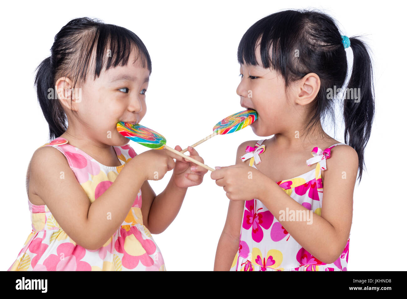 Asian Little Chinese girls eating lollipop in isolated white background Stock Photo