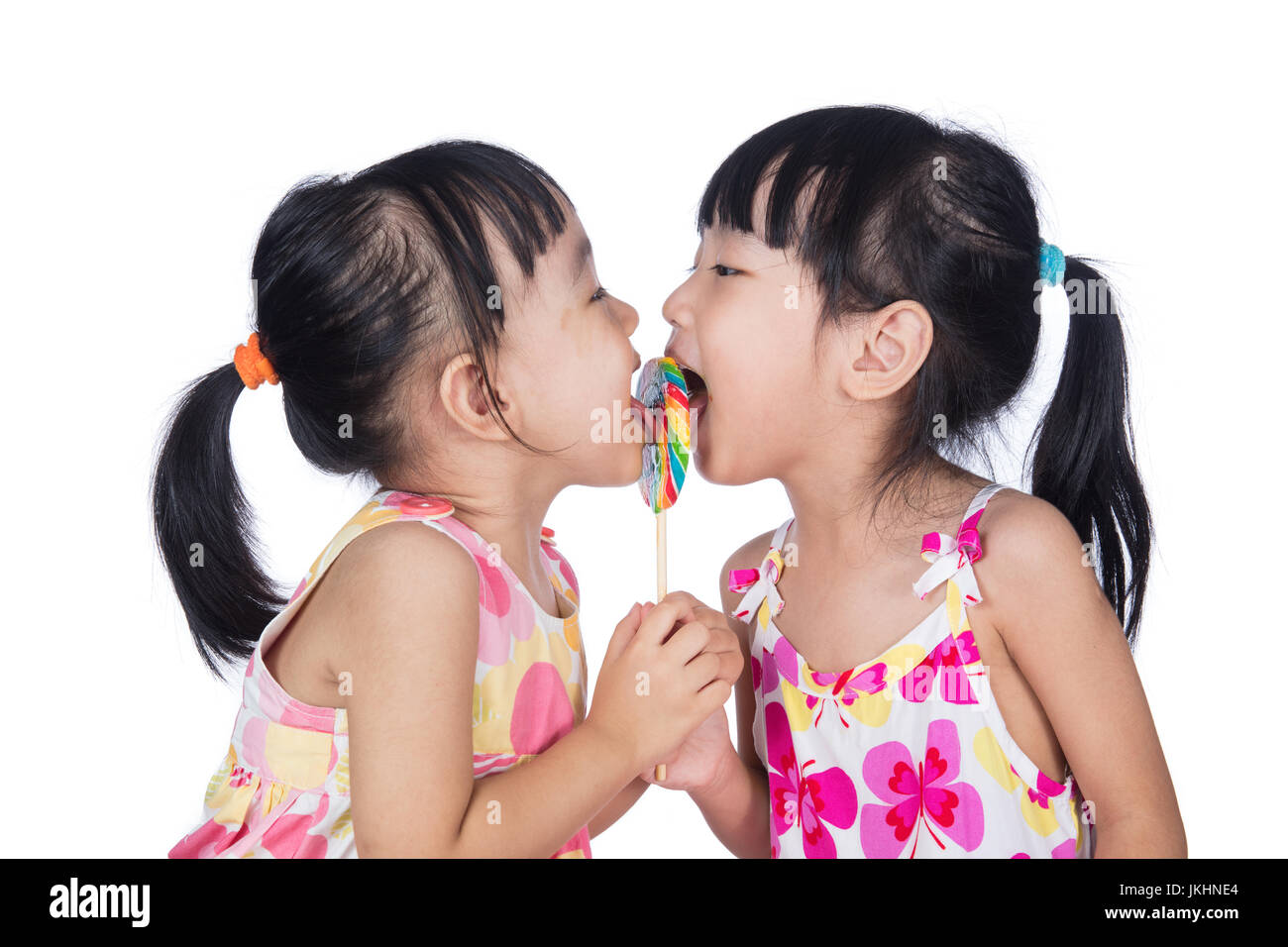 Asian Little Chinese girls eating lollipop in isolated white background Stock Photo