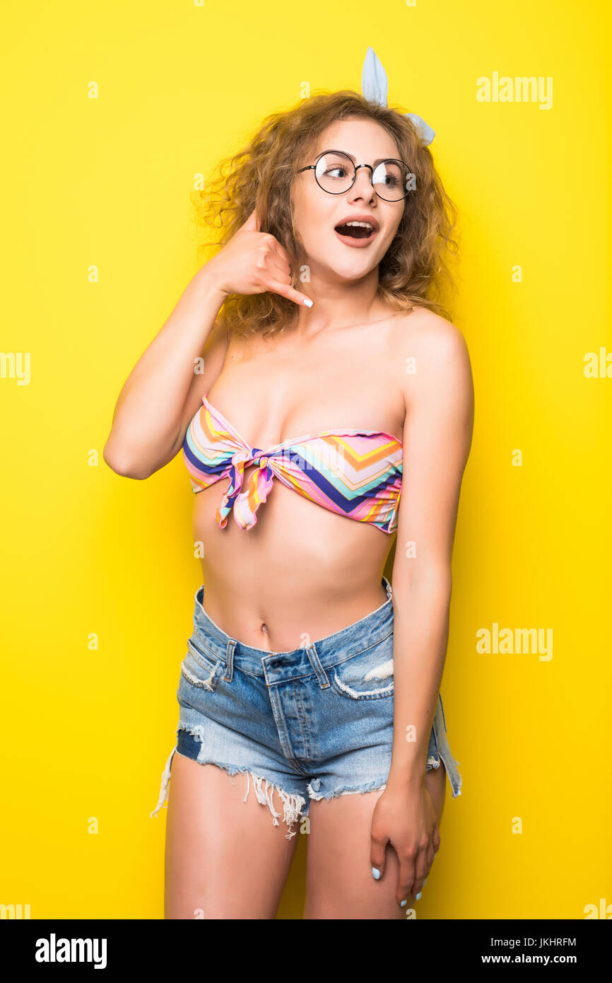 Beauty portrait of a happy young curly joyfull woman over yellow background Stock Photo