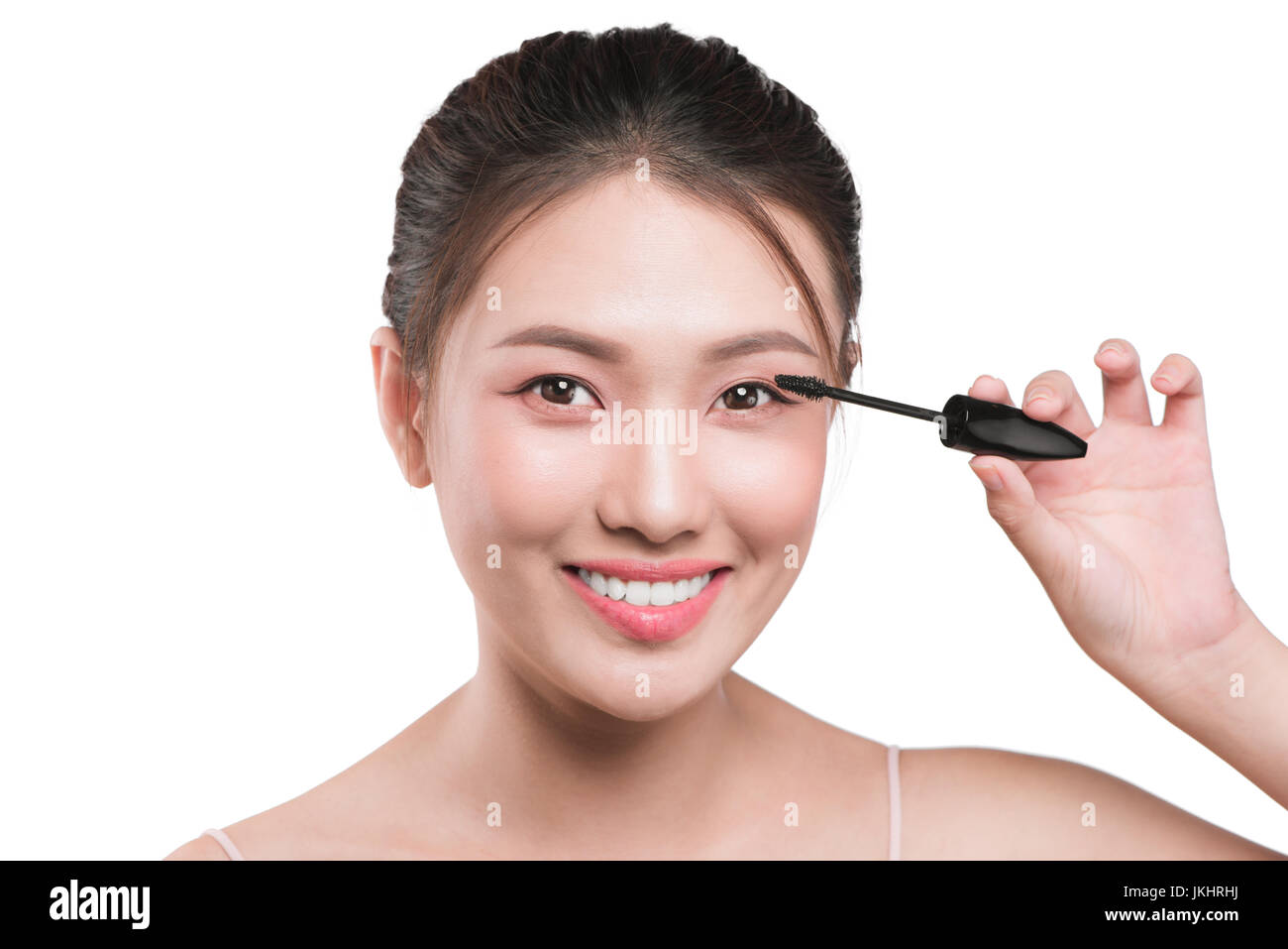 Eye make up apply.  Mascara brush. Portrait of beautiful asian woman with perfect fresh face skin. Stock Photo