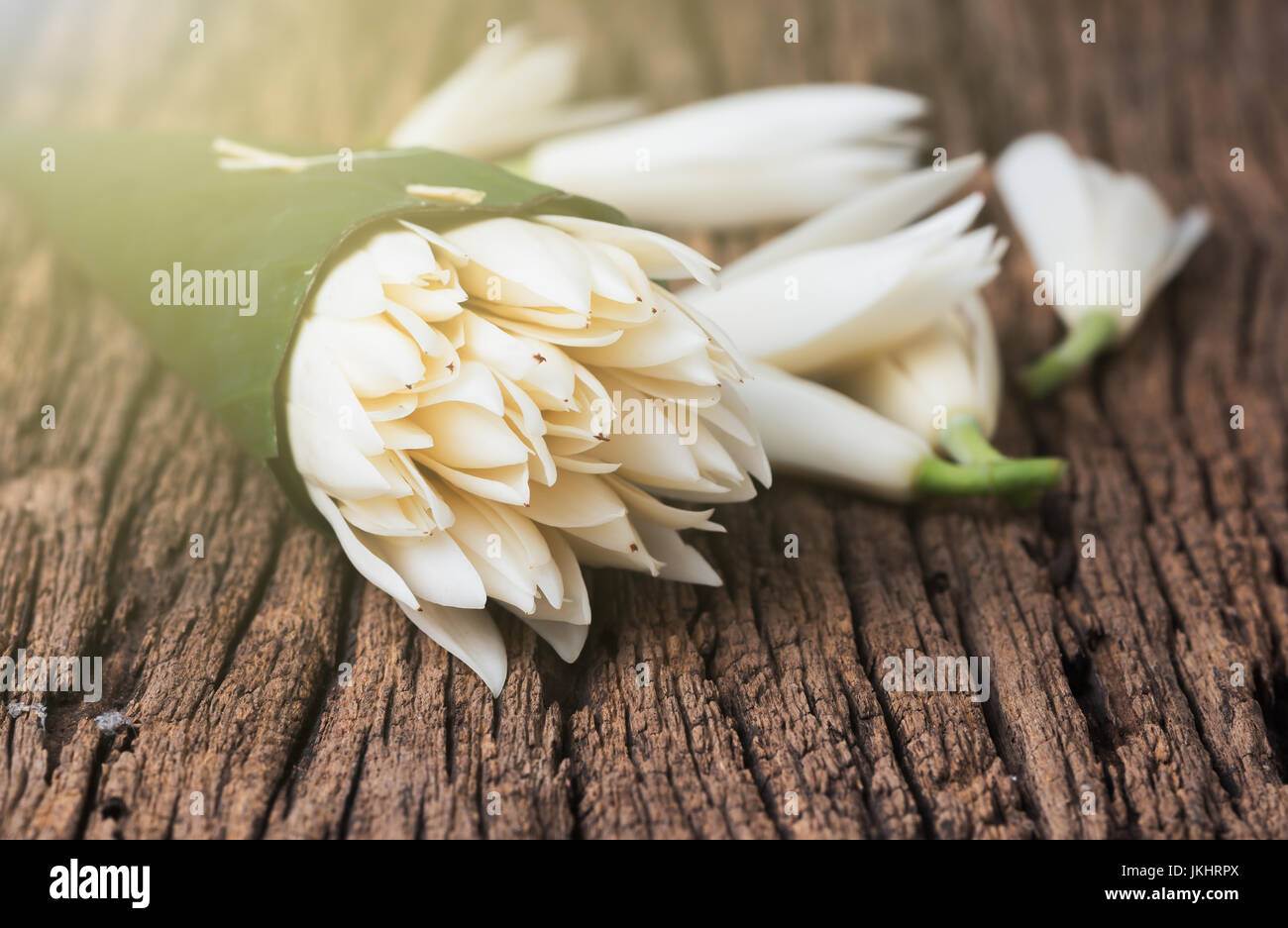 white champaka flower in babana leaf on old wooden background JKHRPX