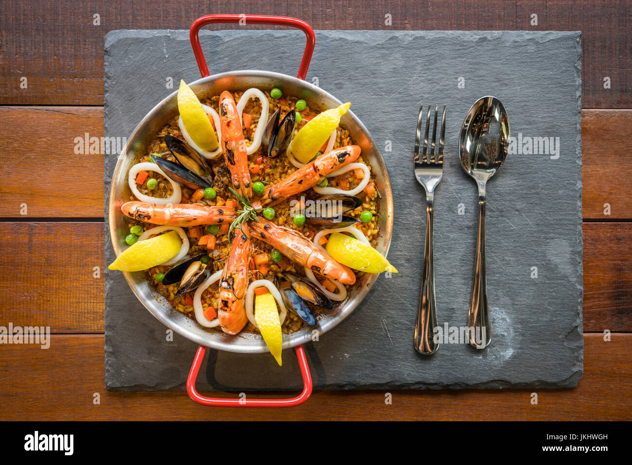 Paella with seafood vegetables and saffron served in the traditional pan top view. Stock Photo