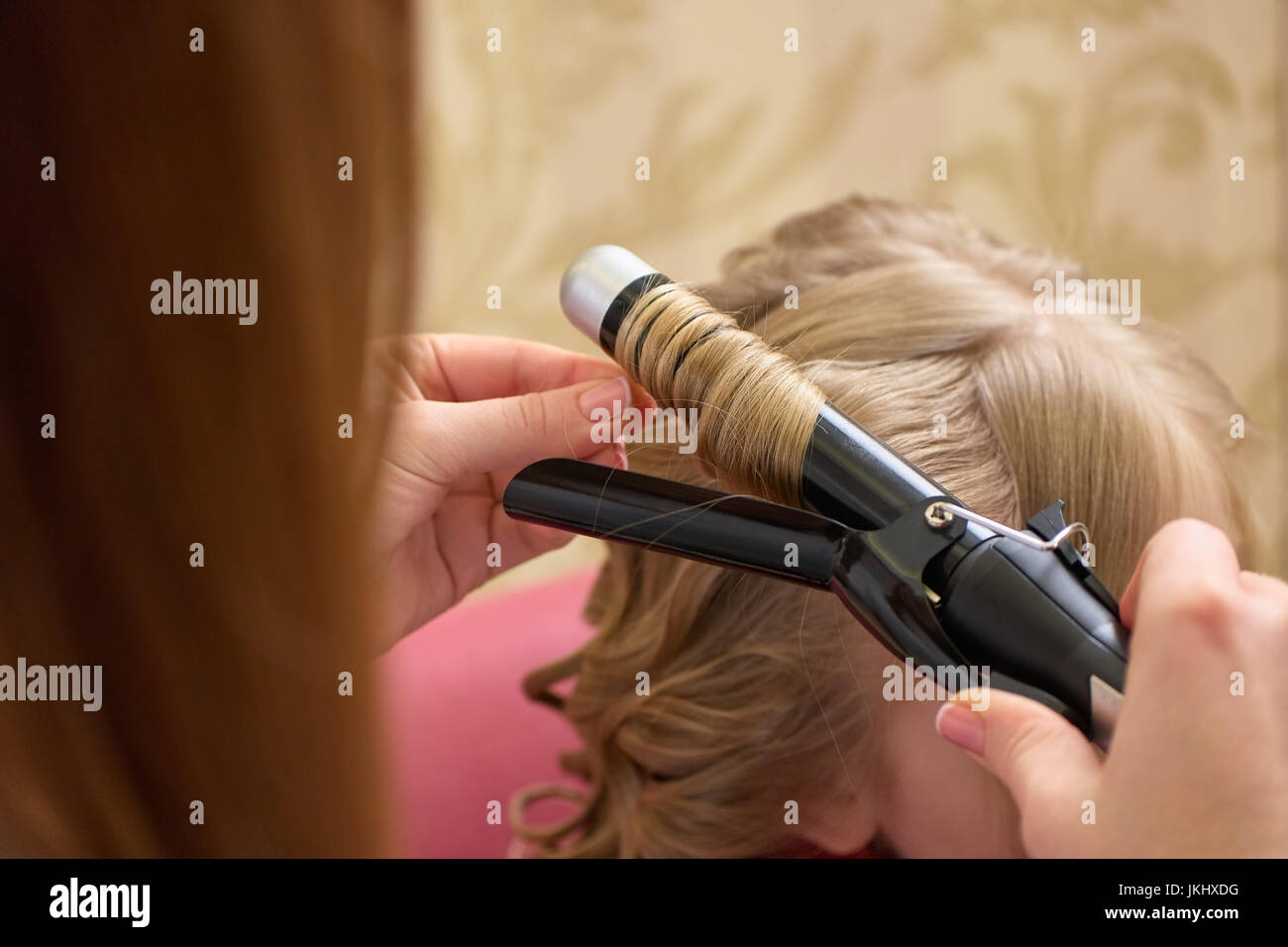 Hands using curling iron Stock Photo Alamy