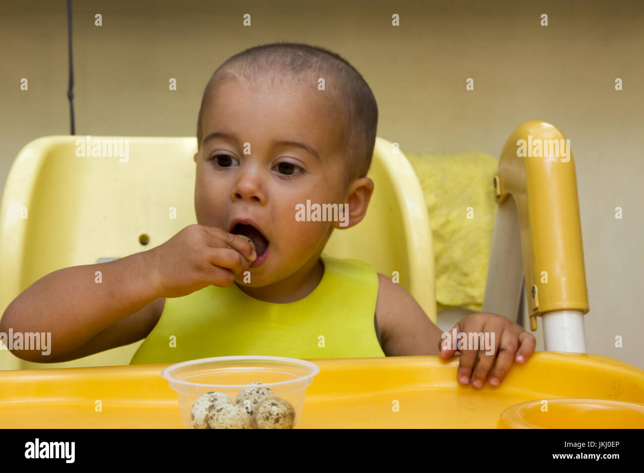 Baby boy eating quail eggs Stock Photo - Alamy