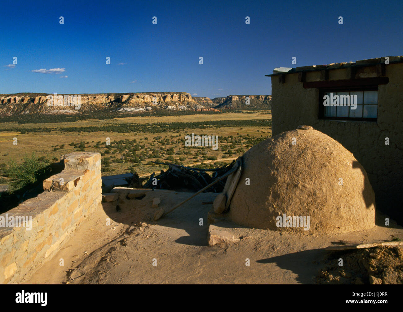 Acoma Pueblo (Sky City), New Mexico: a domed adobe oven outside a stone and adobe house overlooking the valley and sandstone mesas to the SE. Stock Photo